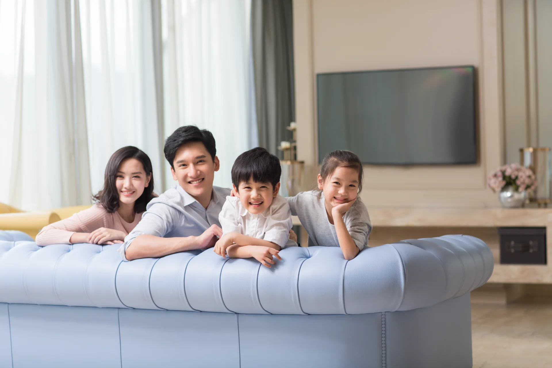 happy family smiling together on a blue sofa 2026 01 05 05 54 25 utc